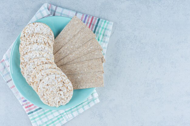 Delicioso pão estaladiço no prato na torre em mármore.