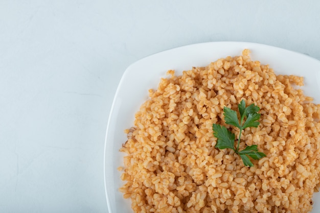 Foto grátis delicioso pilaf de bulgur em um prato branco