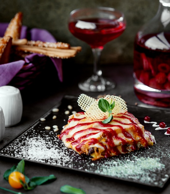 Delicioso prato com queijo derretido, guarnecido com molho azedo em listras