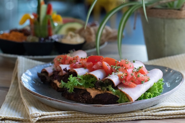 Foto grátis delicioso sanduíche com presunto, alface, tomate e cebolinha