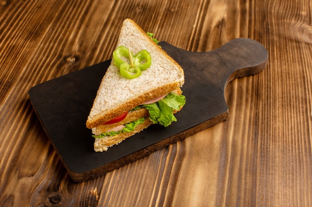 Foto grátis delicioso sanduíche com tomate salada verde e presunto no marrom