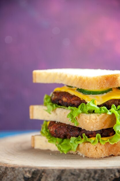 Delicioso sanduíche de carne com salada verde em frente à mesa colorida