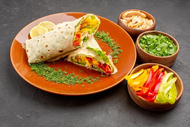 Delicioso sanduíche de salada shaurma fatiado com verduras no espaço escuro de frente