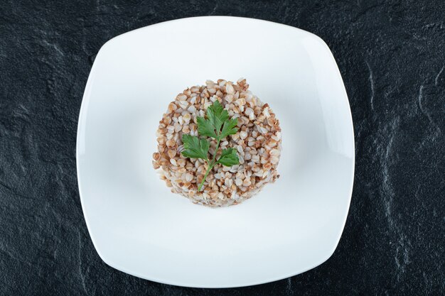 Delicioso trigo sarraceno com verduras em um prato branco