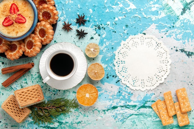 Deliciosos biscoitos com waffles de café e sobremesa de morango na superfície azul da vista de cima