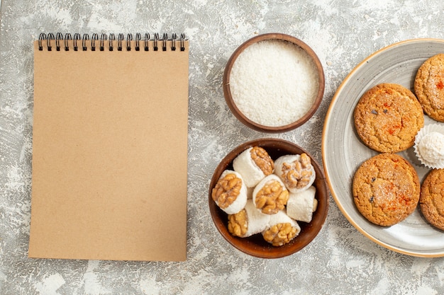 Deliciosos biscoitos de areia com doces na mesa branca de cima