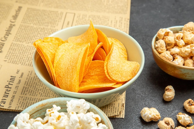 Deliciosos cips de queijo com diferentes petiscos em fundo escuro de vista frontal