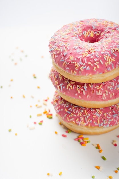 Foto grátis deliciosos donuts empilhados com vidros e granulado
