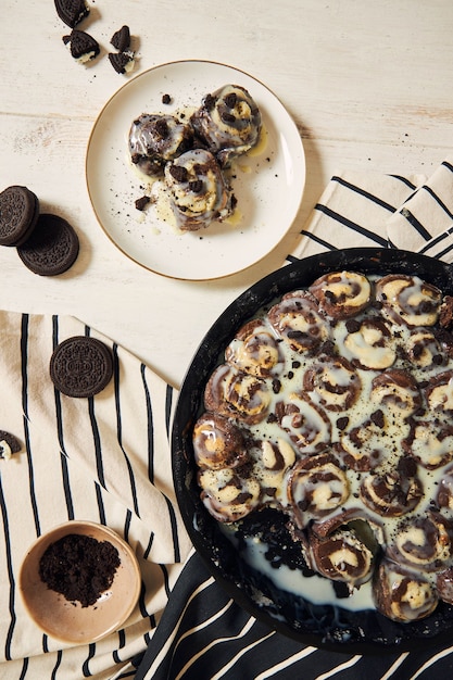 Deliciosos e doces rolinhos de canela com creme branco em um prato