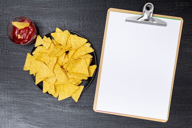 Foto grátis deliciosos nachos com molho ao lado da prancheta