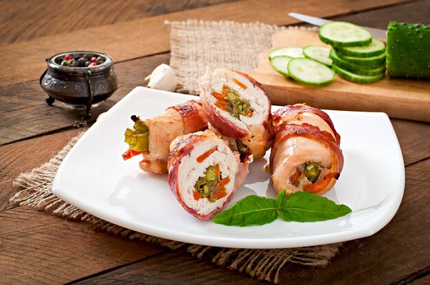 Deliciosos pãezinhos de frango recheados com feijão verde e cenoura embrulhados em tiras de bacon