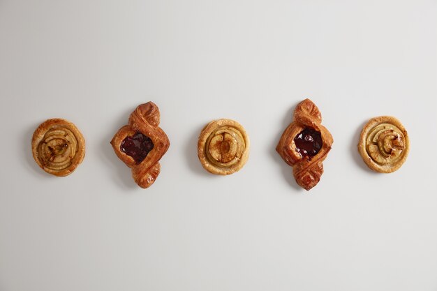 Deliciosos pastéis ou biscoitos recheados com geléia, confeitaria recém-assada. Pãezinhos domésticos para assar. Bolos para o chá no café da manhã. Produtos com alto teor calórico, gastronomia, panificação e conceito de doce tentação