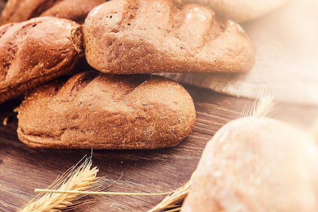 Deliciosos produtos de padaria frescos em fundo de madeira. Foto de close-up de produtos de pão recém-assados.