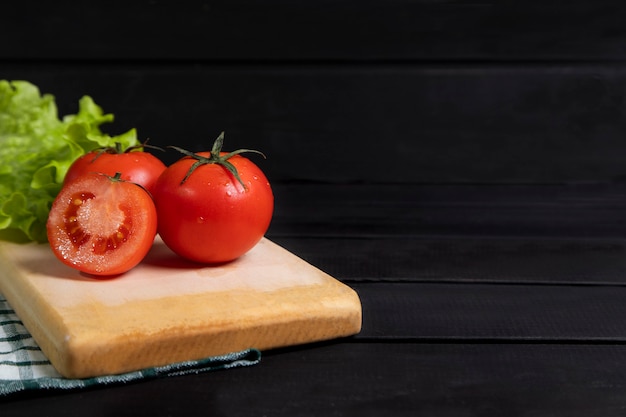 Deliciosos tomates vermelhos colocados na placa de madeira. Foto de alta qualidade
