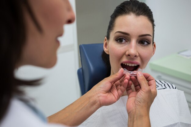 Dentista, ajudando um paciente a usar aparelho invisível