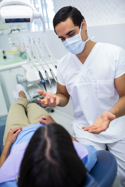 dentista conversando com a paciente do sexo feminino