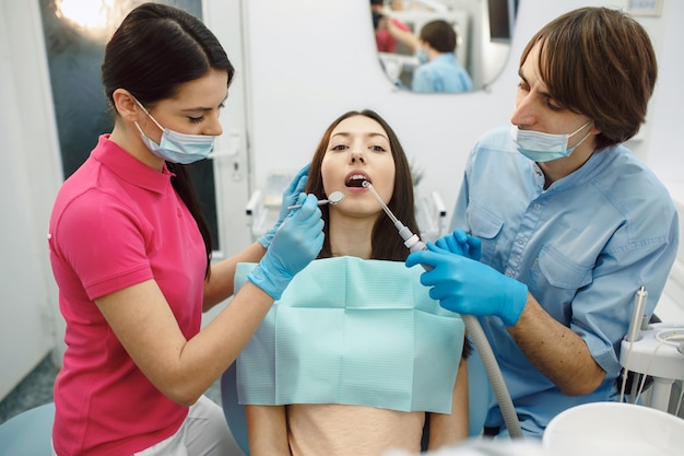Dentista e assistente com um paciente jovem