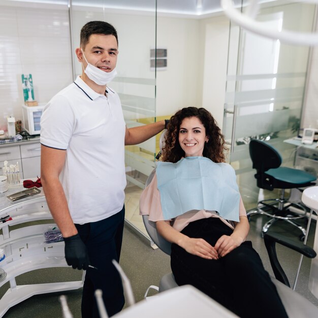 Dentista e paciente posando e sorrindo