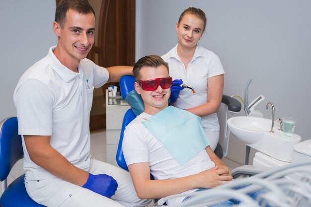 Dentista e paciente posando e sorrindo