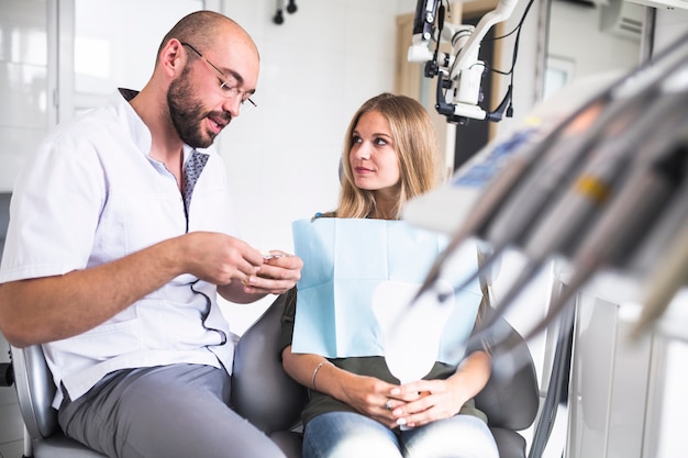 Dentista, falando, com, femininas, paciente, enquanto, trabalhando, ligado, dental, mandíbula