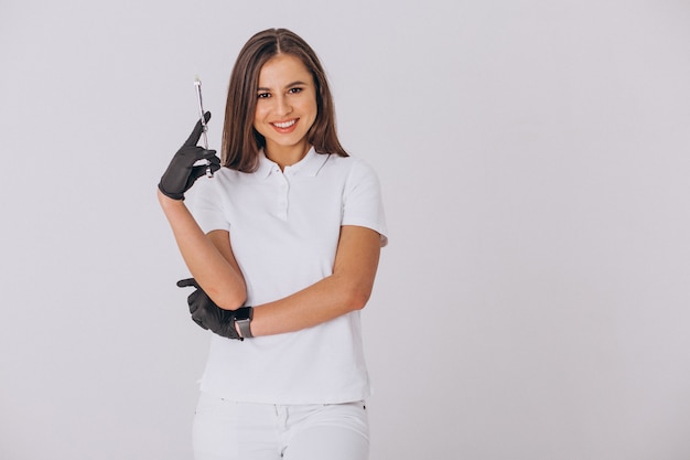 Dentista feminina com ferramentas de Odontologia isolado