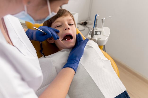 Dentista limpando dentes de criança