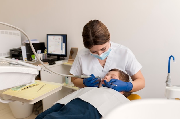 Dentista limpando dentes de criança