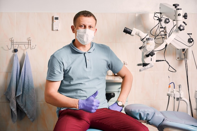 Dentista masculino bonito dando polegares para cima