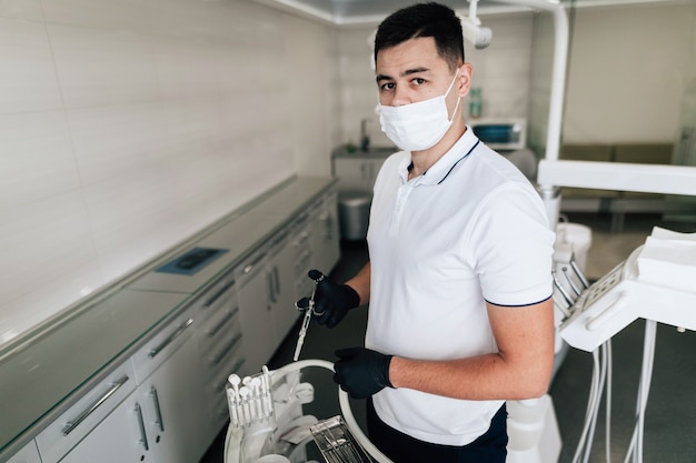 Dentista posando com máscara e equipamento cirúrgico