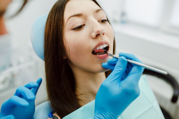 Dentista que trabalha nos dentes do seu paciente