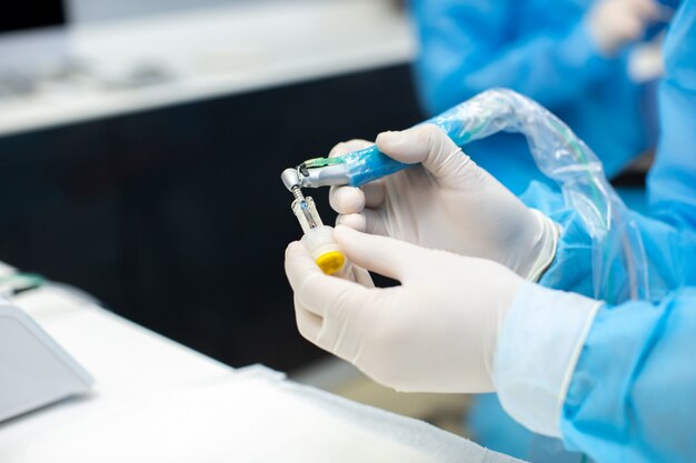 Dentista, segurando a ferramenta dental nos braços