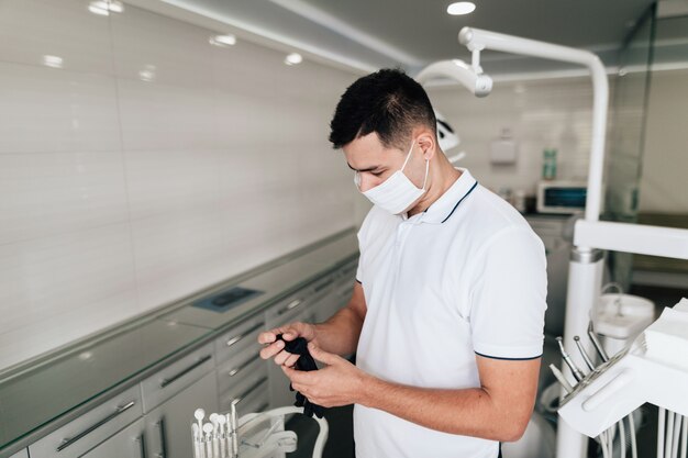Dentista segurando luvas cirúrgicas no escritório