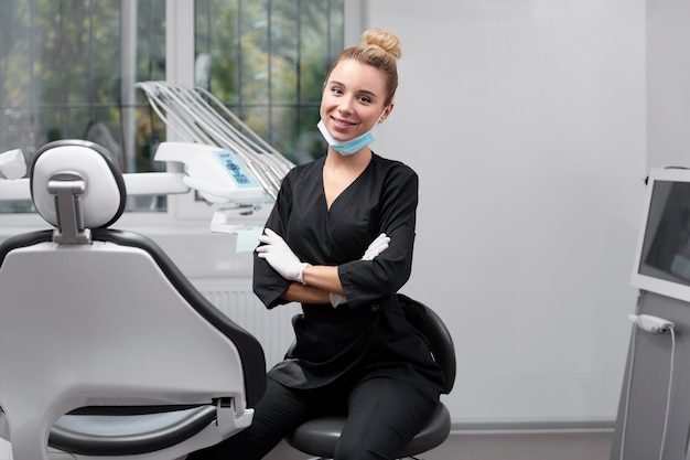 Dentista sorridente de tiro médio no trabalho