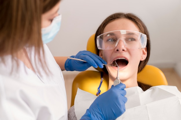 Foto grátis dentista verificando cuidados médicos para pacientes