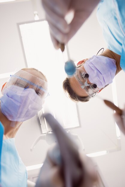 Dentistas segurando instrumentos dentários