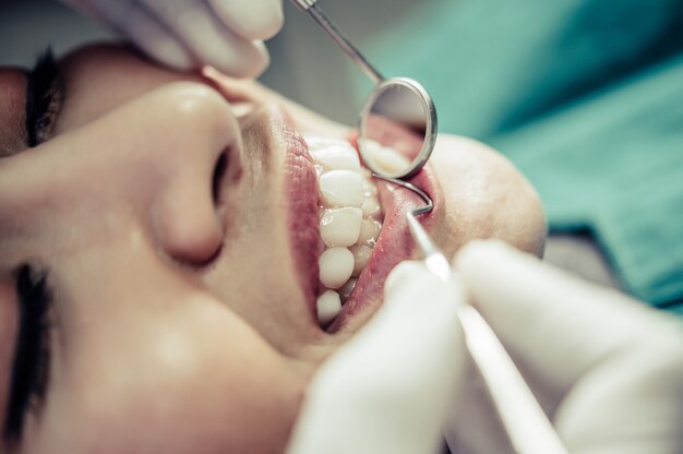 Dentistas tratam os dentes dos pacientes.