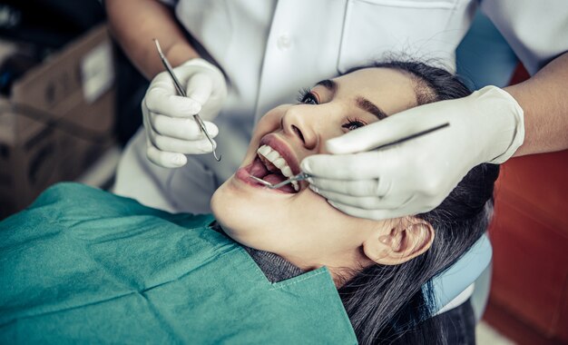 Dentistas tratam os dentes dos pacientes.