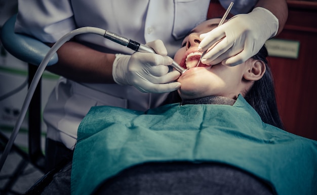 Dentistas tratam os dentes dos pacientes.