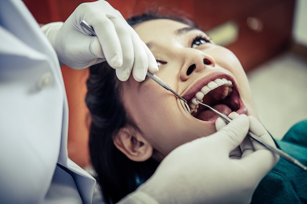 Dentistas tratam os dentes dos pacientes.