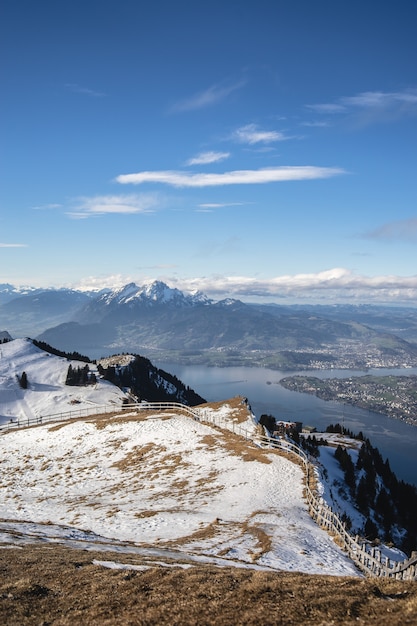 Deque coberto de neve com vista panorâmica da montanha Rigi e um lago suíço sob um céu azul