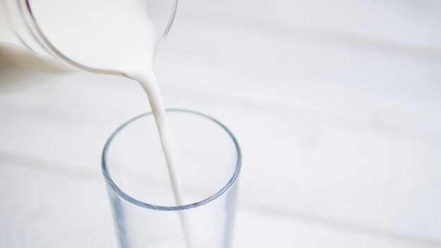 Derramar leite insida um copo