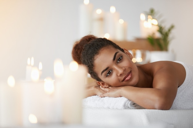 Descanso de sorriso da mulher africana bonita que relaxa no salão de beleza dos termas.