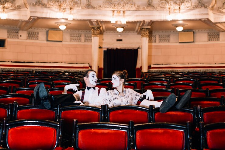 Foto grátis descontraído feminino e masculino mime sentado na poltrona no auditório