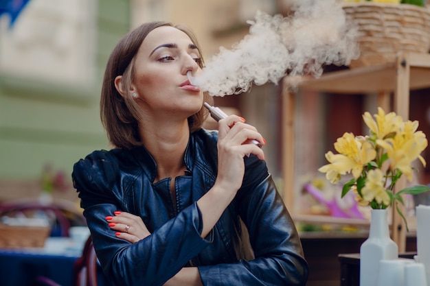 Descontraído mulher fuma o cigarro eletrônico