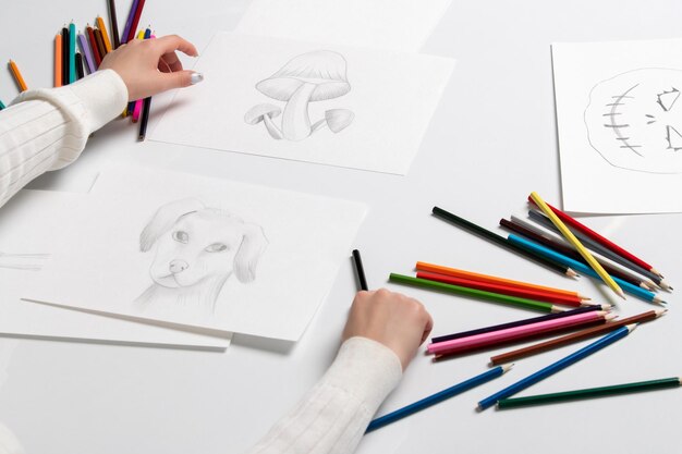 Desenhando a mão de uma jovem nos desenhos de cogumelos de coelho e abóbora de halloween