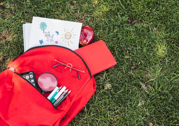 Foto grátis desenhos perto de mochila vermelha com papelaria e smartphone