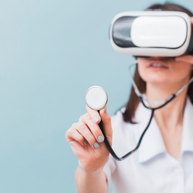 Desfocado médica usando fone de ouvido de realidade virtual e estetoscópio