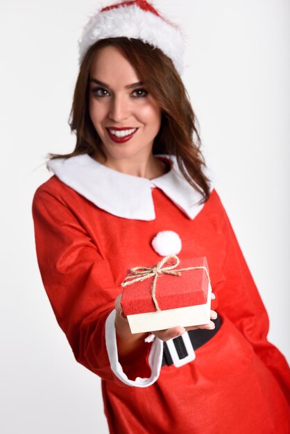 Desgastando de sorriso mulher roupa de Papai Noel com uma caixa de presente