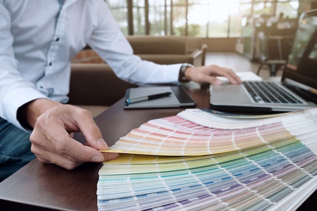 Design gráfico e amostras de cores e canetas em uma mesa. Desenho arquitetônico com ferramentas de trabalho e acessórios.