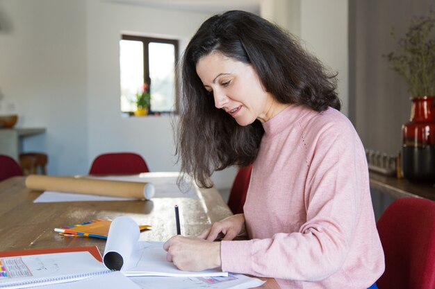 Designer de apartamento sério positivo focado no trabalho